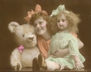 Vintage colorized photo of little girl with doll
