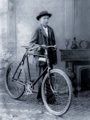 A boy posing with his bicycle in 1910