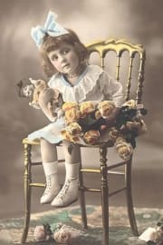 Vintage colorized photo of little girl with doll